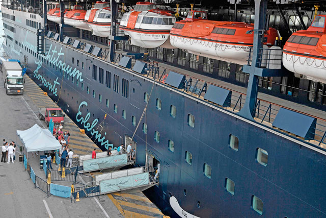 Tourists board a cruise ship at the passenger terminal in the port of Piraeus on Wednesday (AFP photo)