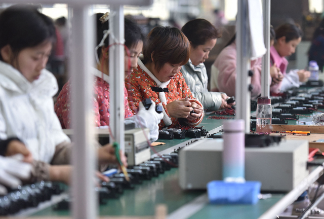 Employees work on an assembly line producing speakers at a factory in Linquan county, Fuyang city, in China's eastern Anhui province on Monday (AFP photo)