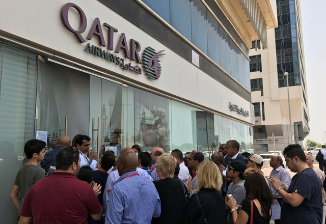 People gather outside a branch of Qatar Airways in the United Arab Emirate of Abu Dhabi on Tuesday (AFP photo)