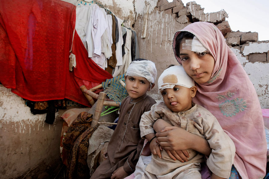 Pakistani children sit in the rubble of their home damaged from an earthquake in Peshawar, on Wednesday (AP photo)