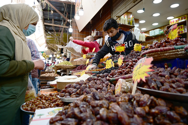 A woman buys dates, a Ramadan staple, from a shop in downtown Amman, in this recent photo (Photo by Amjad Ghsoun)