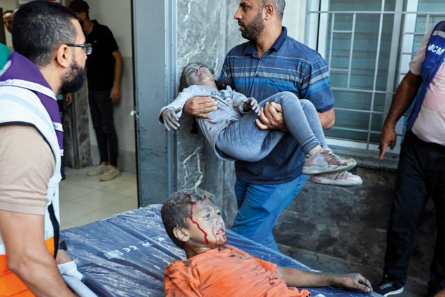 Emergency responders bring wounded children to Al Shifa Hospital following Israeli strikes in Gaza City on Tuesday (AFP photo by Mohammed Abed)