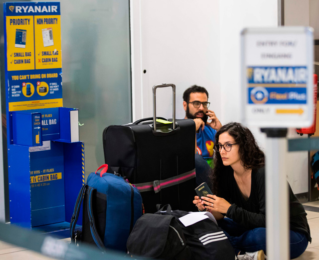 In this file photo taken on August 10, 2018, Ryanair passengers sit on the terminal floor at Schoenefeld Airport in Berlin, after their Ryanair flight was cancelled because of pilots strike  (AFP photo)
