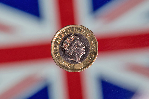 In this photo, taken on December 14, 2017, a British one pound sterling coin is arranged in front of a Union flag for a photograph in London (AFP file photo)