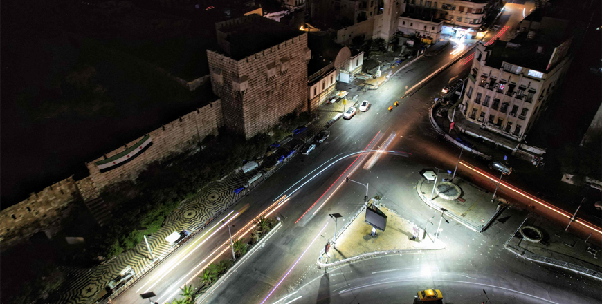 This aerial nighttime view shows a slow exposure of traffic moving at along Thawra (Revolution) Street by the Damascus Citadel in the city centre late on December 22, 2024 (AFP photo)