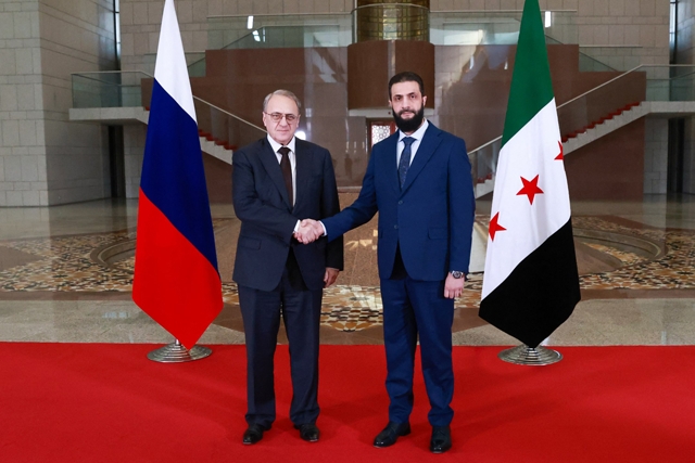 A handout picture released by Syria's transitional government today shows Syria's new leader Ahmed al-Sharaa (R) and Russia's Deputy Foreign Minister Mikhail Bogdanov posing for a picture during their meeting in Damascus (AFP photo)