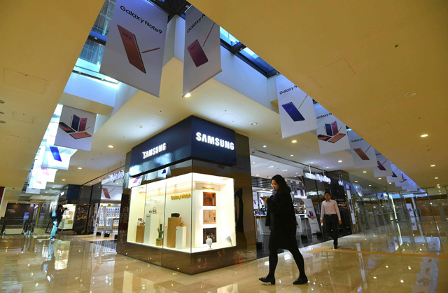A woman walks past advertisements for the Samsung Galaxy Note9 at the company's showroom in Seoul, on Wednesday  (AFP photo)