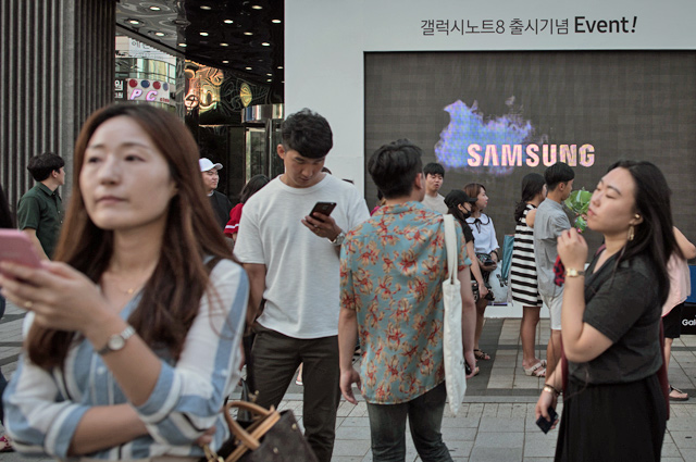 Pedestrians passing a Samsung promotional event outside a store in Seoul, on August 25, 2017  (AFP file photo)