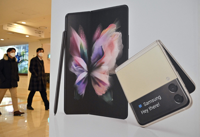 People walk past an advertisement for the Samsung Galaxy Z Fold3 and Flip3 smartphones at the company's Seocho building in Seoul on Friday, after South Korean tech giant Samsung Electronics said it expects its operating profits for Q4 to soar 52.5 per cent (AFP photo)