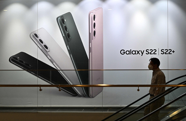 A man walks past an advertisement for the Samsung Galaxy S22 smartphone at the company's Seocho building in Seoul, on Thursday (AFP photo)
