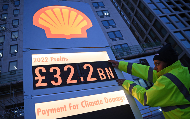 Activists from Greenpeace set up a mock-petrol station price board displaying the company's net profit for 2022, as they demonstrate outside the headquarters of Shell, in London on Thursday, as the British energy company announce their full-year results (AFP photo)