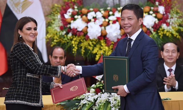 Egypt's Minister of International Cooperation Sahar Nasr (left) and Vietnam's Minister of Industry and Trade Tran Tuan Anh (2nd right) exchange signed documents, as Egypt's President Abdel Fattah Al Sisi (2nd left) and his Vietnamese counterpart Tran Dai Quang applaud, during a signing ceremony of bilateral agreements at the presidential palace in Hanoi, on Wednesday (AFP photo)