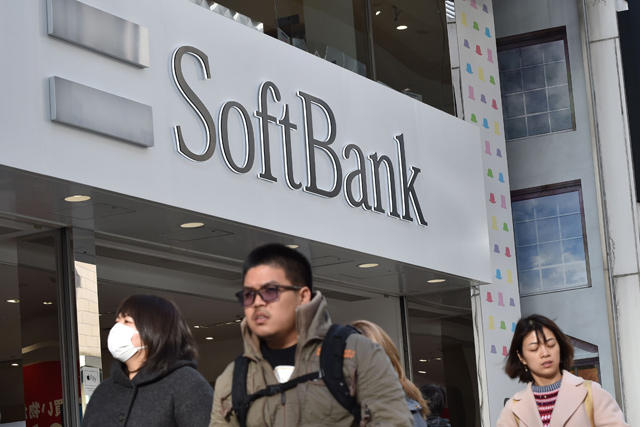 In this file photo taken on February 8, 2017, people walk past a shop of Japanese mobile provider SoftBank in Tokyo's shopping district of Ginza (AFP photo)