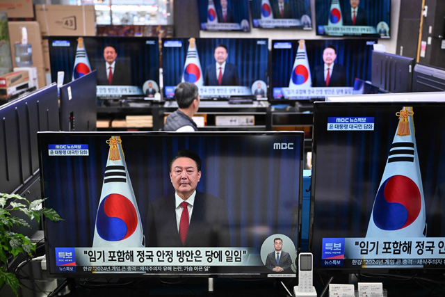 Television screens show live footage of an address by South Korea's President Yoon Suk -yeol, at an electronic market in Seoul on Saturday (AFP photo)