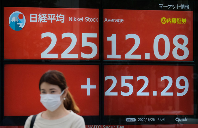 A pedestrian walks past an electronic quotation board displaying share prices of the Tokyo Stock Exchange in Tokyo on Friday (AFP photo)