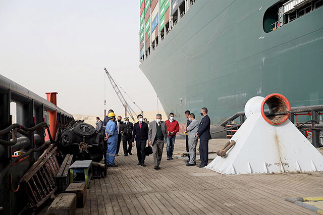  Egyptian officials on Thursday check the operation trying to free Taiwan-owned cargo MV Ever Given (Evergreen), a 400-metre-long and 59-metre wide vessel, lodged sideways and impeding all traffic across the waterway of Egypt's Suez Canal. (AFP photo)