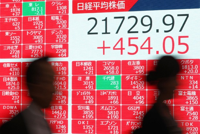 Pedestrians walk past an electronic stock indicator showing the Tokyo stock's closing rate in Tokyo on Monday    (AFP photo)