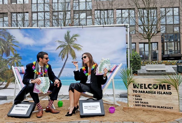 Activists stage a protest on a mock tropical island beach representing a tax haven outside a meeting of European Union finance ministers in Brussels, Belgium, on Tuesday (Reuters photo)