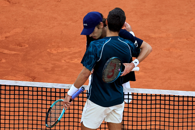 Italy's Lorenzo Musetti (DOWN) speaks with Australia's Alex De Minaur after winning the Monte Carlo ATP Masters Series Tournament semi-final tennis match at the Monte Carlo Country Club in Roquebrune-Cap-Martin on Saturday (AFP photo)