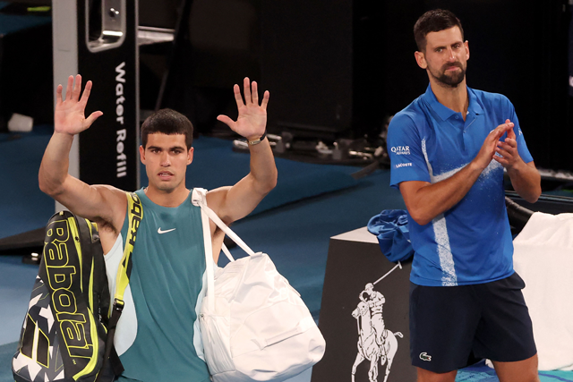 Spain's Carlos Alcaraz (left) acknowledges the spectators as he walks off the court after his defeat to Serbia's Novak Djokovic  in the men's singles quarterfinal match on day ten of the Australian Open tennis tournament in Melbourne on Tuesday (AFP photo)