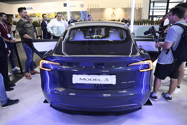 Visitors inspect a Tesla model 3 car on display at the International Motor Show (IAA) in Munich, southern Germany, on Monday (AFP photo)