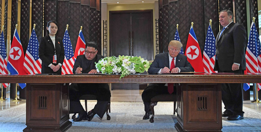 US President Donald Trump (2nd right) and North Korea's leader Kim Jong-un (2nd left) sign documents as US Secretary of State Mike Pompeo (right) and the North Korean leader's sister Kim Yo-jong (left) look on at a signing ceremony during their historic US-North Korea summit, at the Capella Hotel on Sentosa island in Singapore, on Tuesday (AFP photo)