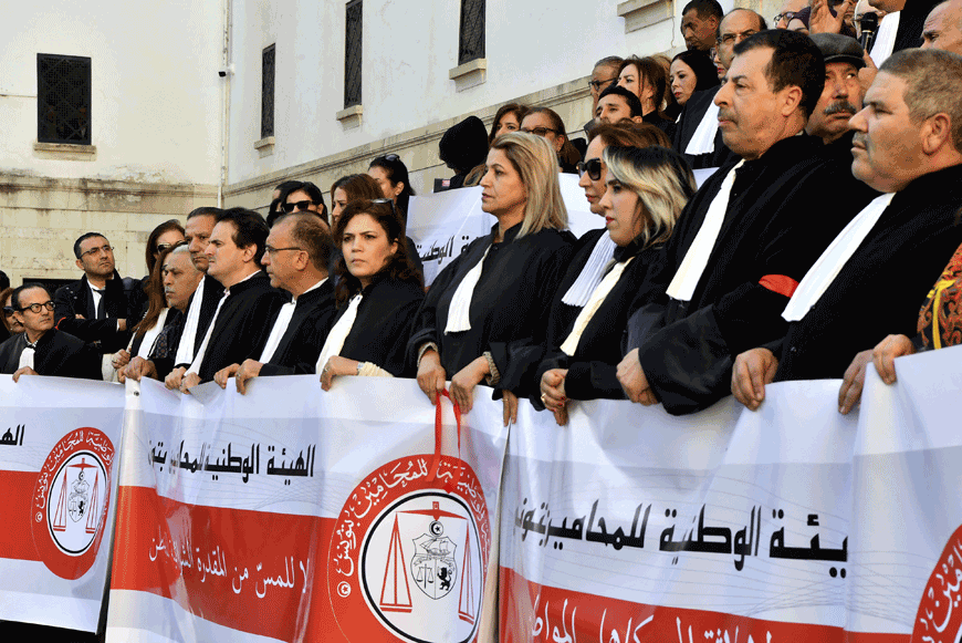 Tunisian lawyers wear a red armband during a lawyers sit in protest against the new finance law, in front of the Tunis court, on Thursday (AFP photo)