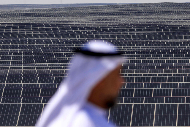 An Emirati man stands in front of photovoltaic panels at al-Dhafra Solar Photovoltaic (PV) Independent Power Producer (IPP) project south of the capital Abu Dhabi, on November 13 (AFP photo)