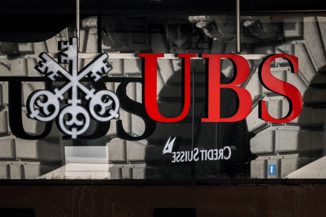A photo shows a logo of Swiss giant bank UBS in front of a logo of Credit Suisse bank in Zurich, on Sunday (AFP photo)