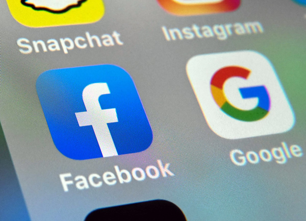 This photo taken on October 1, shows the logos of mobile apps Facebook and Google displayed on a tablet in Lille, France.  (AFP photo)