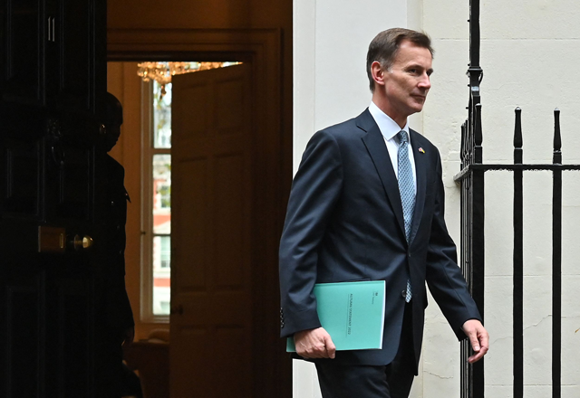 Britain's Chancellor of the Exchequer Jeremy Hunt walks out of Number 11 Downing Street in central London on his way to make a full budget statement in the House of Commons, on Thursday (AFP photo)