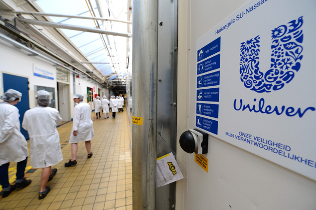 This photo, taken on June 5, 2015, shows employees pass the logo of Unilever at the headquarters in Rotterdam (AFP file photo)