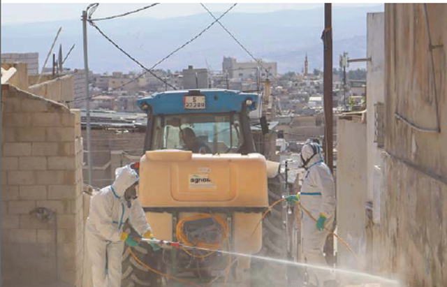 UNRWA sanitation labourers carry out pest control spraying in Jerash camp, also known as ‘Gaza Camp’ due to the large numbers of refugees from the Gaza Strip who were accommodated here following the 1967 war, Jerash camp, Jordan (Photo courtesy of UNRWA)