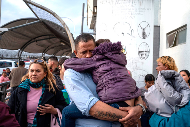 A man from Venezuela seeking asylum in the United States holds his daughter at the entrance to the Paso del Norte International Bridge, on Thursday (AFP photo)