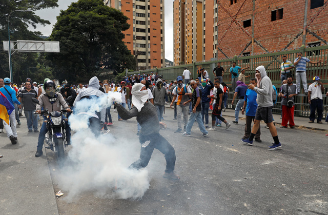 A demonstrator throws back a tear gas canister during a protest against Venezuelan President Nicolas Maduro’s government in Caracas, Venezuela, on Wednesday (Reuters photo)