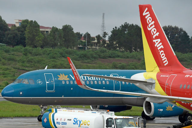 This photo taken on July 29, 2018, shows passenger jets from Vietnam’s two major airlines, Vietnam Airlines and Vietjet (right), on the tarmac at Pleiku Airport in the Central Highlands  (AFP file photo )