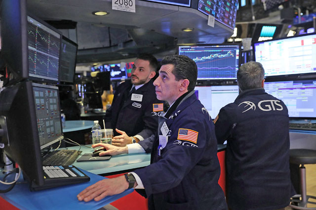 Traders work on the floor of the New York Stock Exchange moments before the closing bell in New York City on Thursday (AFP  photo)