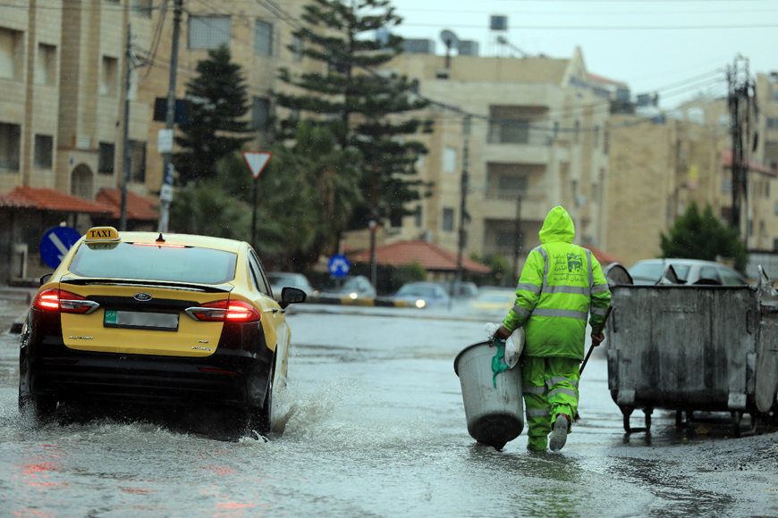 A Greater Amman Municipality worker is seen on duty amid rain in the capital on Sunday (Photo by Sahem Rababah)