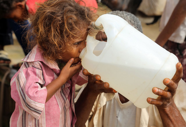 A Yemeni girl drinks water collected from a well in an impoverished village on the outskirts of the port city of Hodeidah, on Sunday, as region has been facing acute water shortages due to drought conditions (AFP photo)