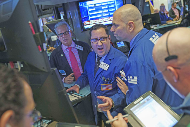 Traders and financial professionals work on the floor of the New York Stock Exchange ahead of the closing bell, in New York City on Monday (AFP photo)