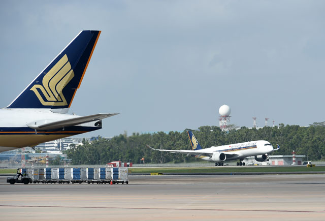 In this photo taken on March 3, 2016, a Singapore Airlines Airbus A350-900 (right) lands at Singapore International Changi Airport  (AFP file photo)