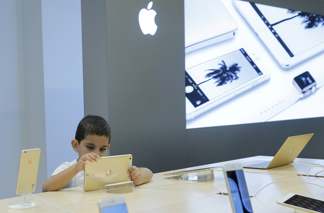 A boy views an iPad at an Apple shop in the Central Universal Department Store in Moscow, Russia, on July 31, 2015. Apple will begin a trial against chip supplier Qualcomm in San Diego on Monday, alleging illegal patent licensing practices (Reuters file photo)