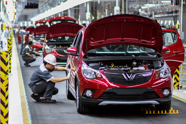 Workers operate the car assembly line at the new automobile plant of VinFast, Vietnam’s first homegrown car manufacturer in Haiphong, on Friday (AFP photo)  