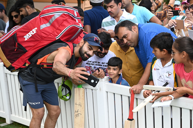 India’s captain Virat Kohli (Left) takes a selfie with a young fan before a training session ahead of the fourth and final Test against Australia at the Sydney Cricket Ground in Sydney on Wednesday (AFP photo)