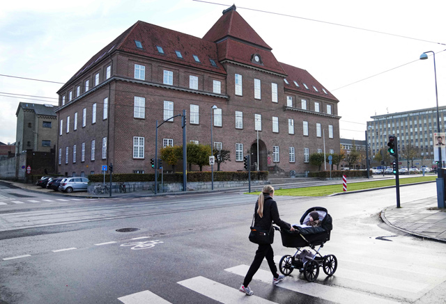 A woman pushes a pram in front of the courthouse in Odense, Denmark, where is taking place a trial against the Dan-Bunkering company on Tuesday (AFP photo)