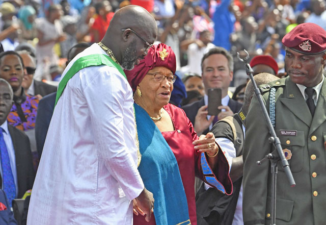 Liberia's President-elect and former football star George Weah (left) stands by the country's former president Ellen Johnson Sirleaf (centre) after he was sworn in during a ceremony in Monrovia on Monday (AFP photo)