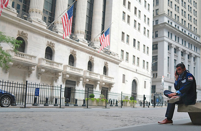 A trader makes a phone call outside the New York Stock Exchange on Monday at Wall Street in New York City  (AFP photo)
