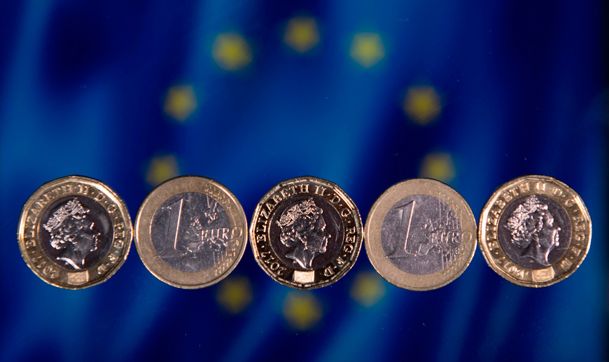British one pound sterling coins and one Euro coins are arranged in front of the European Union flag in a photograph in London, on December 14, 2017 (AFP file photo)