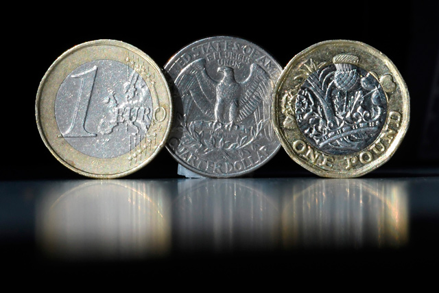A British one pound sterling coin, a one euro coin and a US quarter dollar coin are arranged and photographed in central London on October 5, 2017 (AFP file photo)