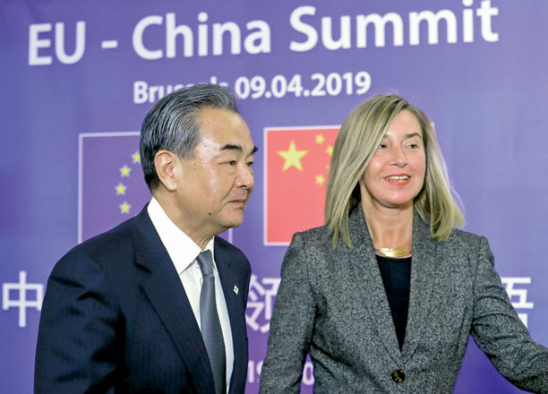 Chinese Foreign Minister Wang Yi is welcomed by Federica Mogherini, high representative for foreign affairs and security policy ahead of a meeting at the European Council in Brussels, Belgium, on Tuesday (Reuters photo)